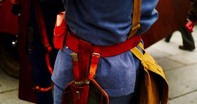Soldier of the First World War. WW1 soldier in blue uniform with a gun, bayonet knife, military ammunition on the belt. Officer of the Great War in Europe. Historical reconstruction of the World War