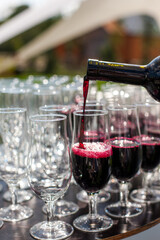 Red wine pouring from the bottle in glass