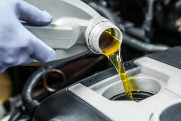 Car oil is pouring into the engine close up. pouring new oil into the engine. automobile engine oil...