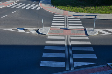 directionally divided lanes at intersection. crossing has a raised safety island for pedestrians....
