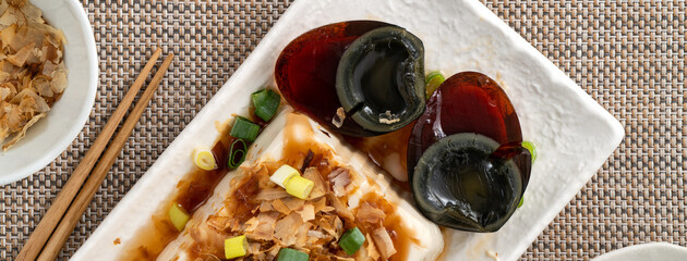 Delicious Chilled tofu and century egg with soy sauce and bonito flakes.