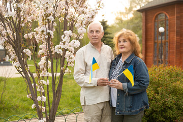 Naklejka na ściany i meble Elderly couple with Ukrainian flag. The independence day of Ukraine. Support for Ukraine.