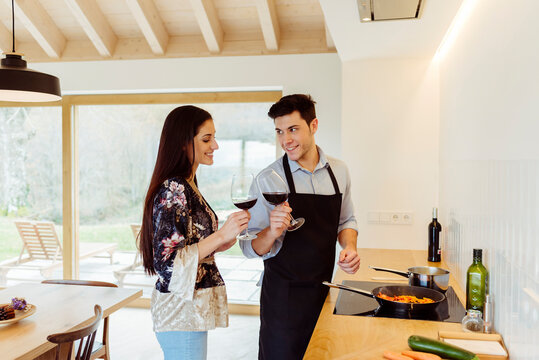 Young couple drinking wine in a glass in the kitchen