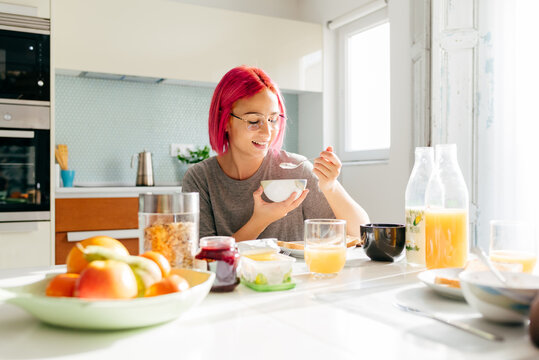 Young lady having healthy breakfast at home