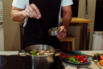 Anonymous man cooking vegetables at home