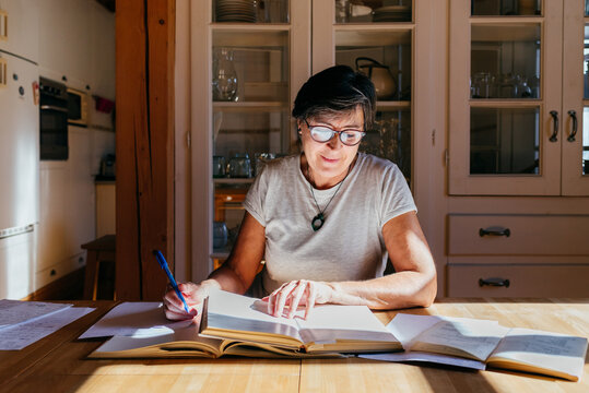 Mature woman with books studying at home