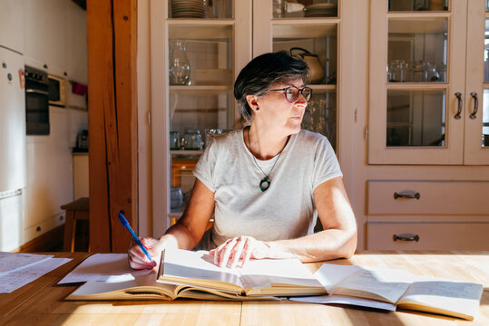 Mature woman with books studying at home