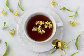 Healthy lime tea in a white cup. Linden tree on a white background. Top view