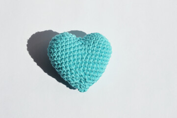 crocheted colored heart on a white background. yarn, cotton, handmade creativity. valentine's day. love.