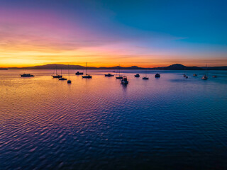 Aerial sunrise waterscape with boats and high cloud