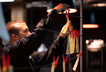 Man hanging papers with orders on kitchen