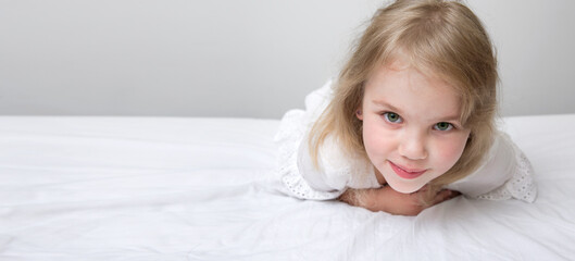 Fototapeta premium Beautiful caucasian kid in bed empty copy space. Smiling toddler portrait healthy lifestyle design.