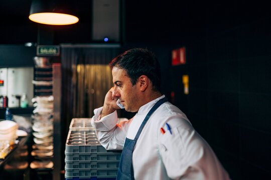 Chef speaking on phone in kitchen