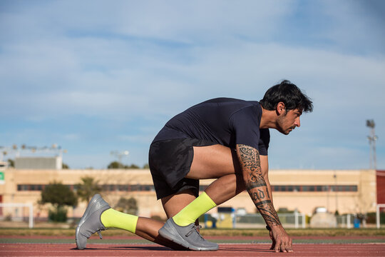 Sportsman in crouch start position at stadium