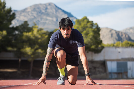 Sportsman in crouch start position at stadium