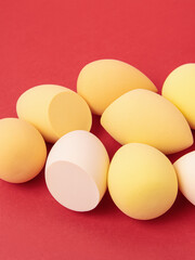 Set of yellow makeup soft sponges on red background