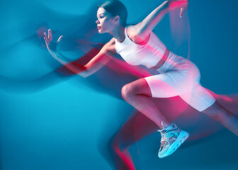 Endurance running. Female athlete run at high speed in pink neon light. Motion blur. Athletic...