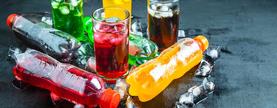 Top view  lot of bottles Soft drinks in colorful and flavorful  on the table, Glasses with sweet drinks with ice cubes