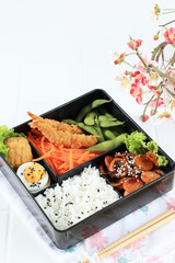 Japanese Bento Box with Egg, Nugget, Ebi Furai, Edamame, and Teriyaki Sausage.