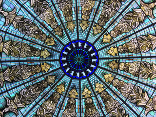 The geometrical stained glass window in blue shades and yellow pieces in perfect radial symmetry