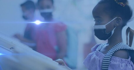 Animation of light spot moving against african american girl wearing face mask at school - Powered by Adobe