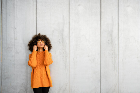 Trendy black woman in bright sweater on street