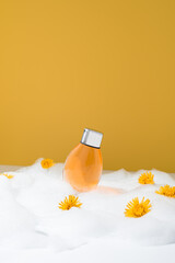 Botella de gel de ducha sobre espuma. Jabón de baño para el cuidado de la piel sobre fondo naranja
