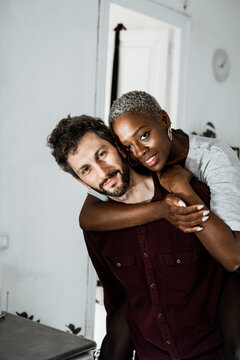 Tender multiethnic couple embracing at home