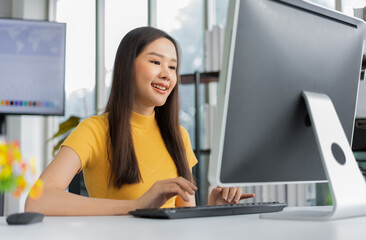 Portrait happy young programmer Asian woman work at start up technology office and using computer for coding application program and fully creative. Concept of smart entrepreneur woman working.