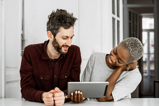 Positive multiethnic couple using digital tablet together - Powered by Adobe