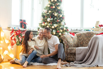 Obraz premium Christmas. Family. Happiness. Top view of dad, mom and daughter on the floor at home.
