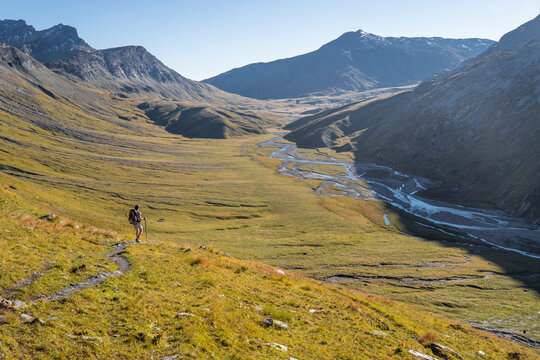Female hiker descending into Greina Valley, Grisons, Switzerland