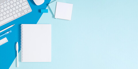 Business concept background. Flatlay, top view of photo of keyboard notepad pencil blank notes stationery on isolated blue table desk background