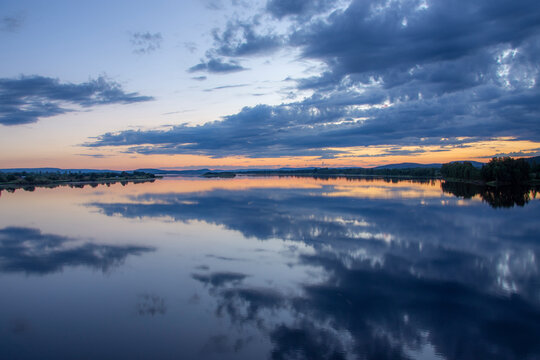 Beautiful cloud reflection on Torne River during midnight sun, Sweden