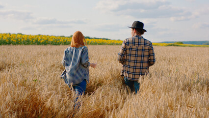 Small family business concept one couple in the middle of wheat field and sunflowers ana the field full of harvest