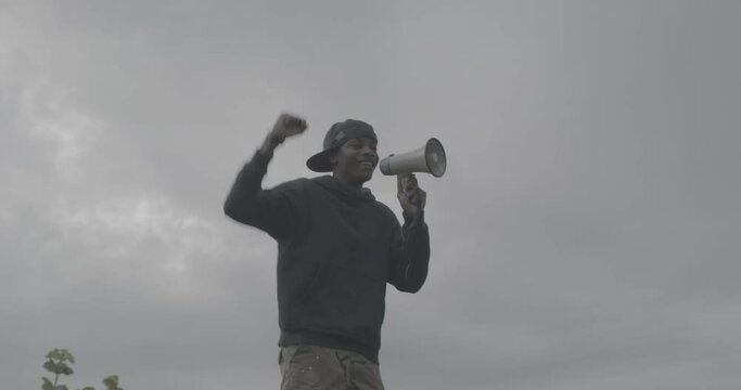 MS Young man protesting at rally with megaphone