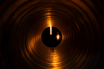 glowing bulbs with edison filament visible from the ventilation duct through the grate, the front and back background is blurred with bokeh effect