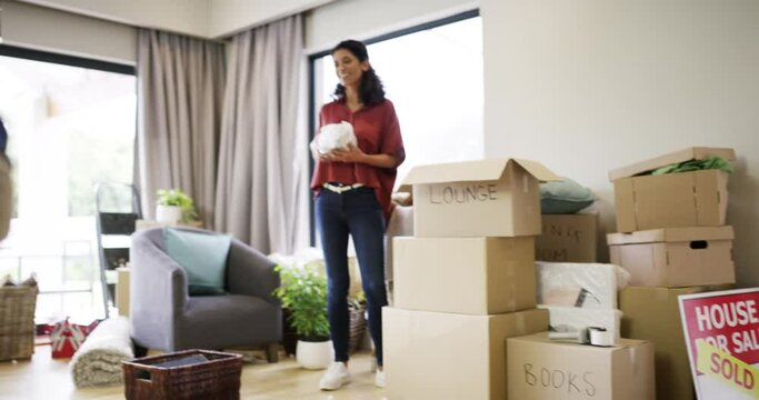 House, box and happy family playing together in their new home. Smiling couple and child having fun in new property purchase. Woman, man and child laughing inside their real estate investment.