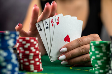 woman sitting on table playing poker holding cards proudly celebrating success very excited.