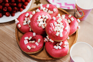 Donuts with sprinkles on pink background. Sugar, calories, homemade sweets concept.