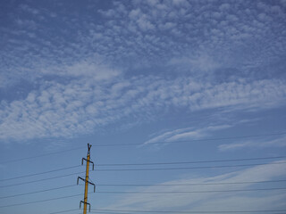 power line pole in close-up against a blue sky background