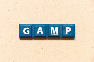 Tile letter in english word GAMP (Abbreviation of Good Automated Manufacturing Practice) on wood background