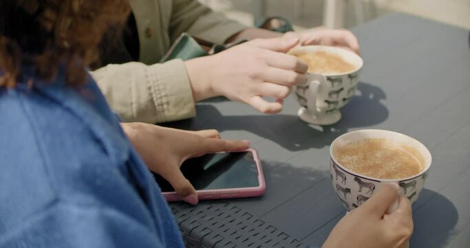 CU SLO MO Female friends drinking coffee in sidewalk cafe