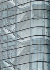 stairways between the floors of a futuristic modern commercial building behind a curved glass facade