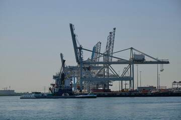 Fototapeta na wymiar ROTTERDAM, THE NETHERLANDS - New container terminal with a very large container ship and in the foreground a smaller inland container ship on the Maasvlakte of the port of Rotterdam