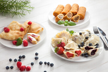 Dumplings with strawberries, blueberries, pancakes with raspberries, croquettes with cabbage, and meat
