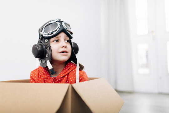 Child in pilot helmet and goggles dreaming about future