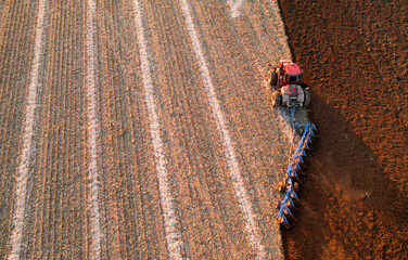 Tractor Plowing field, top view. Cultivated and soil tillage. Tractor on land cultivating....