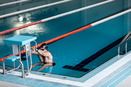 Swimmer in goggles and cap exercising in pool