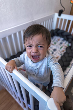 Screaming and crying baby ethnic boy in crib
